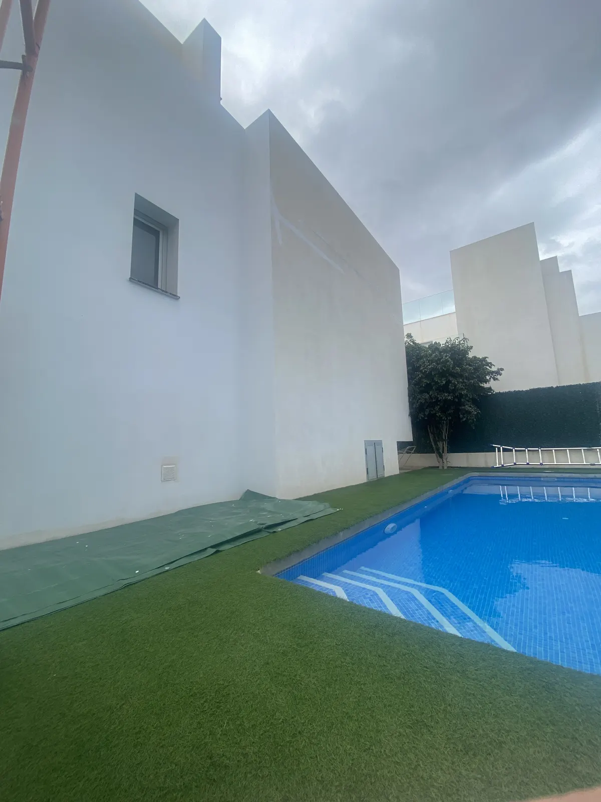 Après : façade de villa repeinte en blanc au-dessus de la piscine
